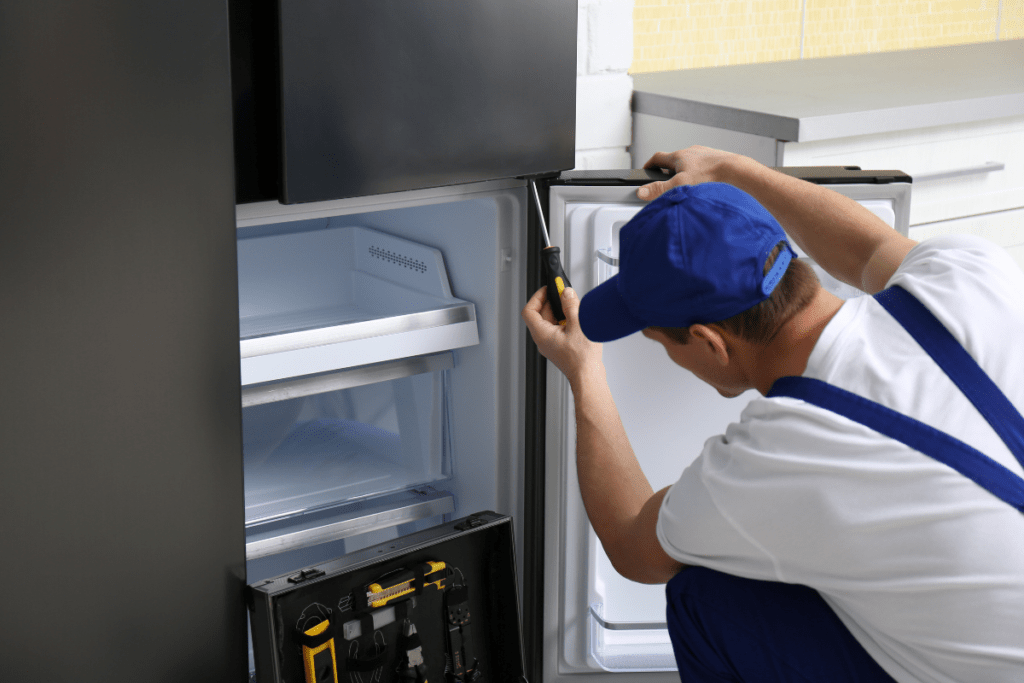 Technician Servicing Freezer During Appliance Repair Visit