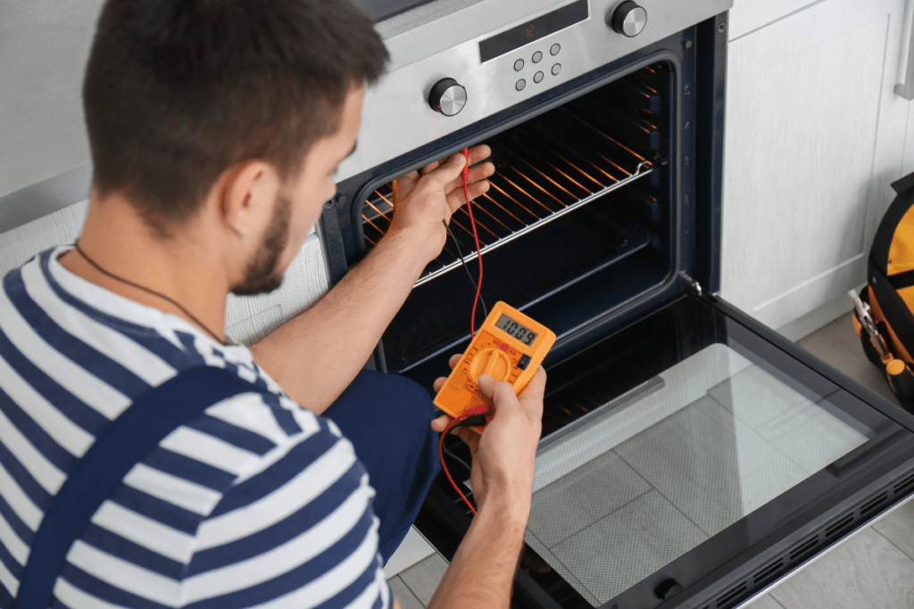 Technician checking an oven for repair issues