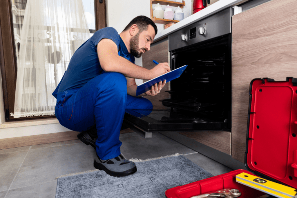 Technician inspecting an oven for repair