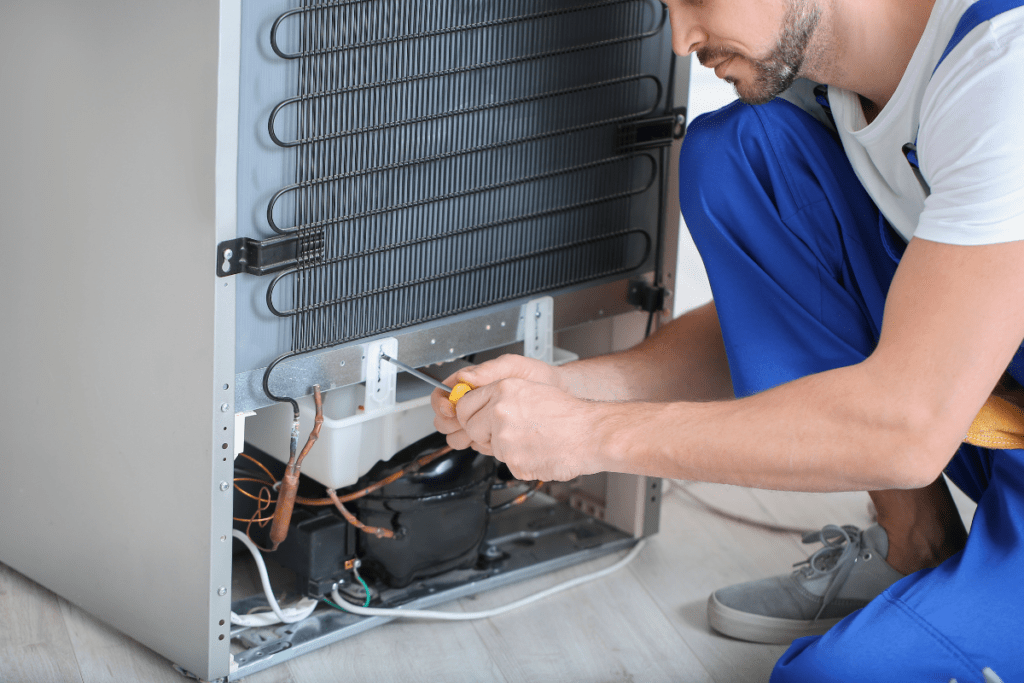 Appliance Repair Expert Fixing Refrigerator For Maryland Homeowner