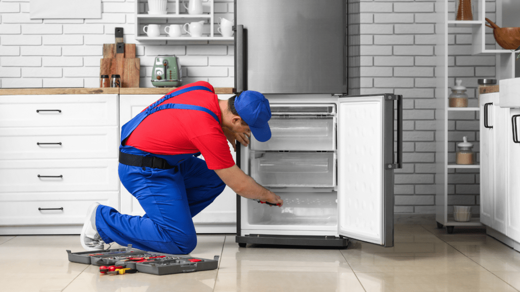 Technician inspecting a bottom freezer refrigerator for appliance repair in North Potomac MD