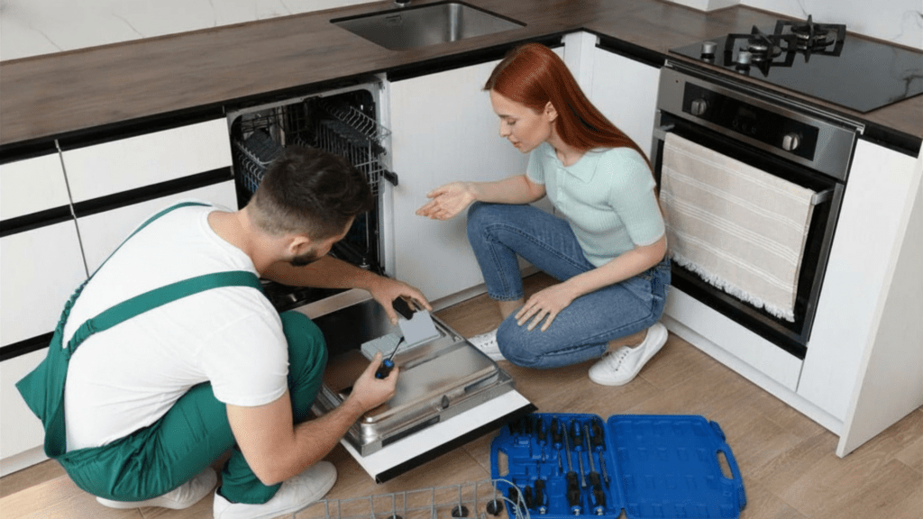 Technician explaining a dishwasher diagnosis to a homeowner in the kitchen for appliance repair in Reston VA
