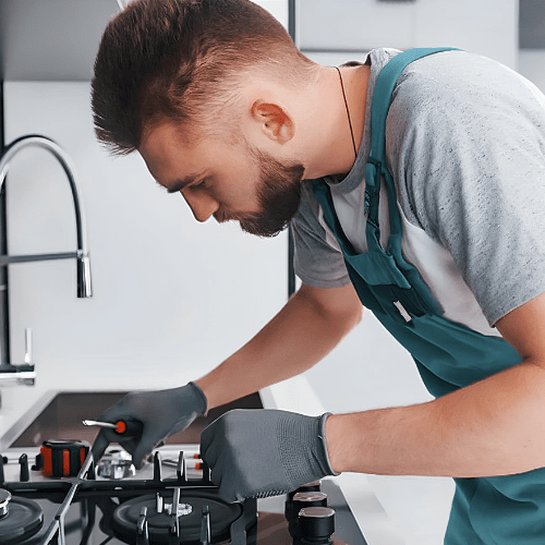 Technician repairing a cooktop for appliance repair in Hyattsville MD