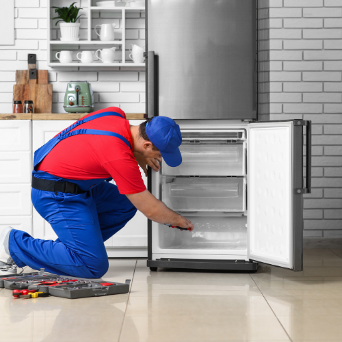 Technician inspecting a bottom freezer refrigerator for appliance repair in North Potomac MD