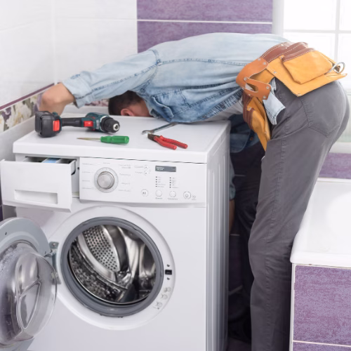 Man repairs a washing machine for Appliance Repair in Four Corners MD