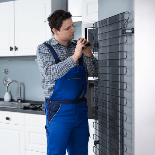Technician repairing a refrigerator in a home for appliance repair in Georgetown DC