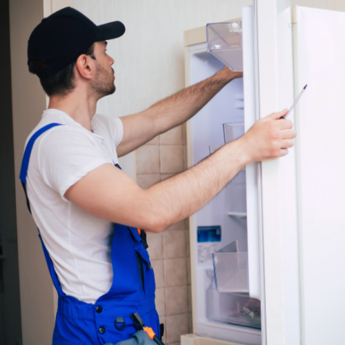 Technician repairing a refrigerator for appliance repair in One Loudoun VA