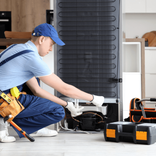 Technician repairing a refrigerator in a kitchen for appliance repair in Friendship Heights DC