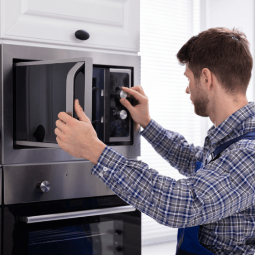 Technician Repairing Microwave Oven for Appliance Repair in Frederick City MD
