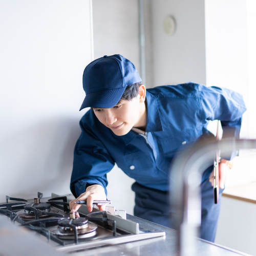 Technician diagnosing a gas stove for appliance repair in Urbana MD